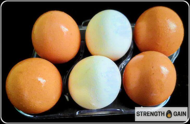 Four brown eggs and two white eggs placed in an egg tray