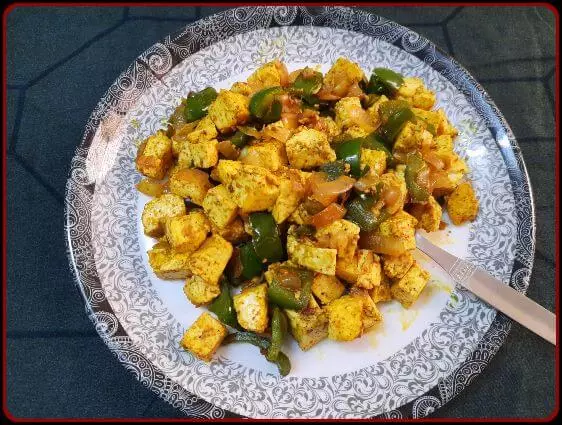 Paneer sauteed with vegetables on a plate.